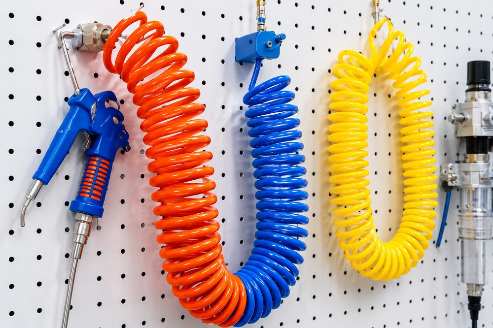 PU recoil coil hoses and a blow gun on a workshop board